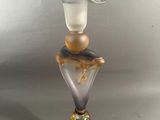 a glass vase with a bird on top of it