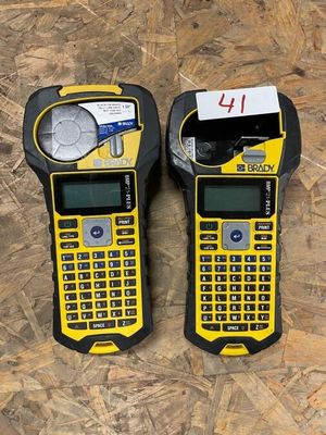 two yellow and black cell phones sitting on top of a wooden floor