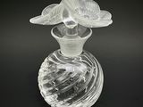 un vase en verre contenant une fleur, posé sur une surface noire