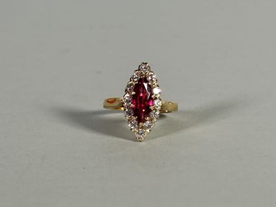 a close up of a red and white diamond ring on a white surface