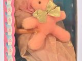 poupée Barbie tenant un ours en peluche rose dans une boîte rose