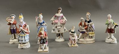 seven figurines of people dressed in different costumes