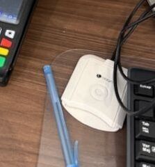 a keyboard and a pen sitting on a desk next to a cell phone