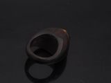 an image of a wooden ring sitting on top of a black surface