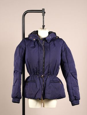 La veste que porte le mannequin est bleue et possède une capuche.