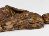statue of a man laying on his back on a white surface