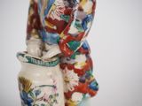 a figurine of a woman holding a vase with flowers on it