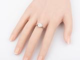 a close up of a person ' s hand with a diamond ring on it