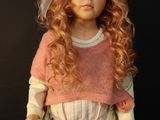 a doll that is wearing a pink dress and a white shirt