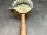 a metal pan with a wooden handle sitting on a table