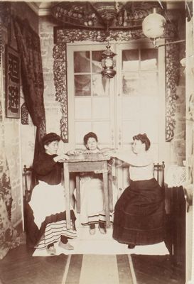 two women sitting at a table in the corner of a room