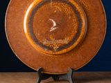 a brown plate sitting on top of a wooden table