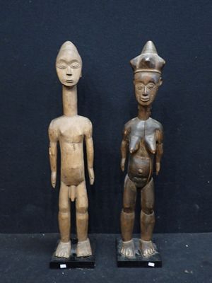 deux figurines en bois représentant un homme et une femme debout l'un à côté de l'autre