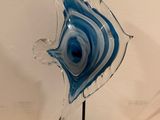 une sculpture en verre représentant un poisson, posée sur un socle noir