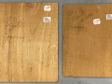 two pieces of wood with stickers on them sitting on top of a table