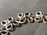 a close up of a metal bracelet on a table