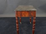 a small wooden table with a marble top and brass legs