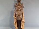 une sculpture en bois représentant un homme dont la tête repose sur un socle