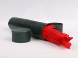 a red umbrella in a black tube on a white surface