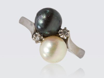 Bague en or gris ornée de deux perles grise et blanche et de…
