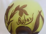 a yellow vase with a brown design on it