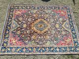 un tapis posé par terre, dans l'herbe