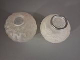 two white vases with designs on them on a table