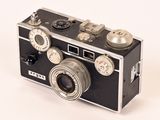 a black and silver camera on a white surface