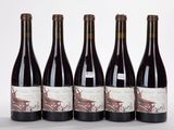 six bouteilles de vin sont alignées sur une surface blanche