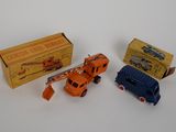 Trois camions miniatures sont posés les uns à côté des autres sur une surface blanche