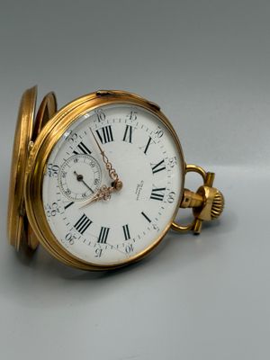 une montre de poche en or avec des chiffres romains sur le cadran