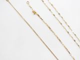a close up of a group of gold necklaces on a white surface
