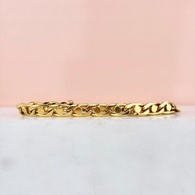 a close up of a gold bracelet on a marble surface