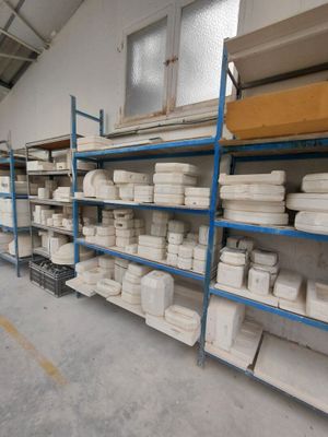 a room with shelves filled with lots of white dishes
