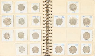 un livre ouvert sur lequel sont posées plusieurs pièces de monnaie différentes