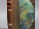 an old book sitting on top of a table next to a gray wall