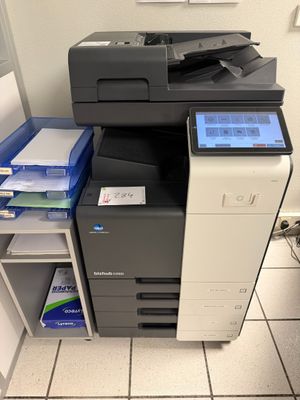 une imprimante multifonction posée sur une étagère dans une pièce