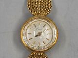 a close up of a gold wrist watch on a white surface