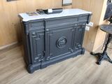 a black cabinet with a marble top in a room