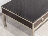 a coffee table with a black top and a silver base