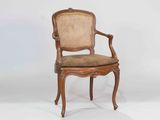 a wooden chair with a cane back and a brown seat