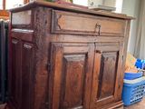 a wooden cabinet sitting on the floor in front of a window