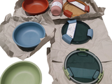 de nombreux bols et assiettes de différentes couleurs sur la table