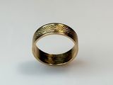 a close up of a gold ring on a white surface