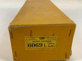 an old yellow box with a label on it sitting on a white surface