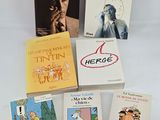 several books are sitting on a white surface with a white background