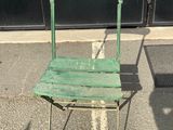 a green chair sitting in the middle of the street