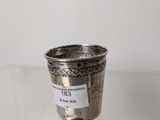 an old silver cup sitting on top of a glass table