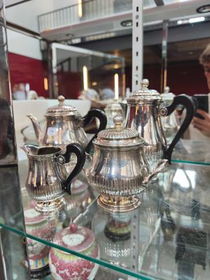 de nombreuses théières en argent exposées dans une vitrine