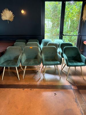 de nombreuses chaises vertes et une table dans une pièce